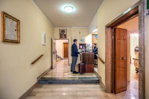 a man standing at a counter in a hallway at Casa per Ferie Ravasco San Pietro in Rome