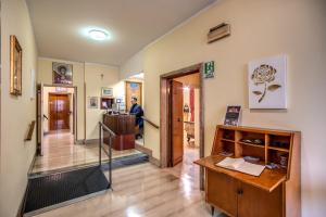 Habitación con escritorio y pasillo con una persona. en Casa per Ferie Ravasco San Pietro en Roma