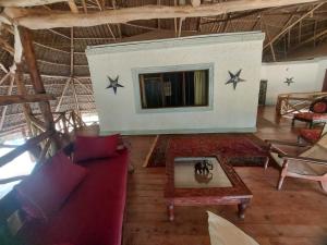 Gulu House في ماليندي: غرفة معيشة مع أريكة ونجوم على الحائط