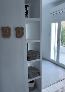 a room with white shelves with towels and a window at Casa Olivo in Iznájar