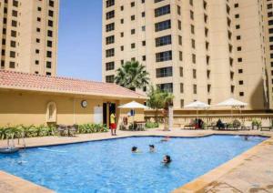 a group of people in a swimming pool with buildings at Ultra Luxury JBR Duplex Penthouse - Beach Resorts Neighbourhood in Dubai
