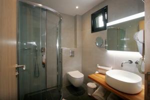 a bathroom with a shower and a toilet and a sink at Oliva Suites in Keramotí
