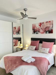 sypialnia z dużym białym łóżkiem z różowymi poduszkami w obiekcie Apartamento Turistico Peñalver Playa 316 w mieście Torrox Costa