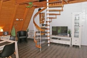 a spiral staircase in a living room with a television at wenige Meter bis zum Strand in Damp