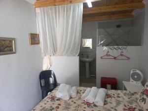 een slaapkamer met een bed met handdoeken erop bij Sugarbush & Burgundy in Zeerust