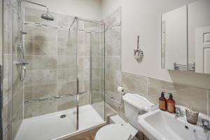 uma casa de banho com um chuveiro, um WC e um lavatório. em Host & Stay - Sandpiper Apartment em Whitby