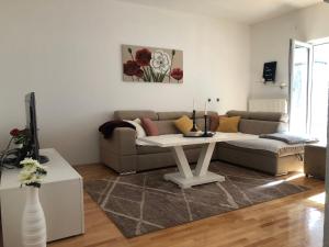 ein Wohnzimmer mit einem Sofa und einem Tisch in der Unterkunft Apartman Cypres in Kupres