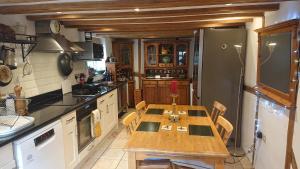 a kitchen with a wooden table and a refrigerator at Charming 17th Century 2-Bed Cottage in Medmenham in Medmenham