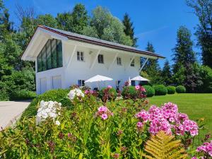 a white house with flowers in front of it at Ferienwohnung WohlfühlEckerl in Tittmoning