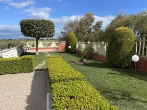un giardino con cespugli tagliati e una recinzione di Capo Rizzuto Home a Capo Rizzuto
