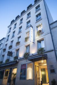 un bâtiment blanc avec des fenêtres et des plantes. dans l'établissement Denfert-Montparnasse, à Paris