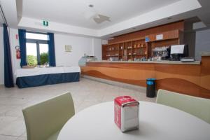 een cafetaria met een tafel en stoelen en een bar bij Baraka Apartments in Scoglitti