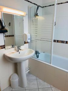 y baño con lavabo, ducha y bañera. en Hôtel SPA Le Tosny, en Épaignes