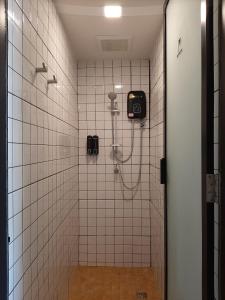 a shower stall in a bathroom with white tiles at Little One in Chiang Rai