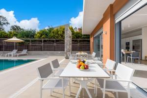 a patio with a table and chairs and a pool at Ialyssos Charme Villa in Ialyssos