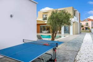 a ping pong table in the courtyard of a house at Ialyssos Charme Villa in Ialyssos