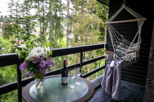 uma mesa com uma garrafa de vinho e copos numa varanda em Hotel Smart em Sinaia