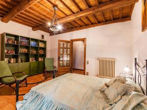 Podere Stabbione Countryhouse - Happy Rentals في Castel Viscardo: غرفة نوم مع سرير كبير ورف كتاب
