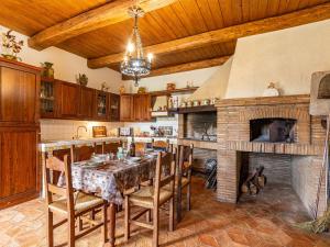 eine große Küche mit einem Tisch und einem Kamin in der Unterkunft Podere Stabbione Countryhouse - Happy Rentals in Castel Viscardo