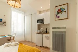 a small kitchen with a table and a desk in a room at VilleneuveCityStay Jungle in Villeneuve-sur-Lot