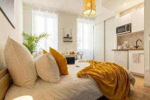 una camera da letto con un letto con cuscini bianchi e gialli di VilleneuveCityStay Jungle a Villeneuve-sur-Lot