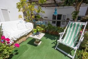 un patio con una silla y una mesa con flores en B&B La Bella Annacapri, en Anacapri