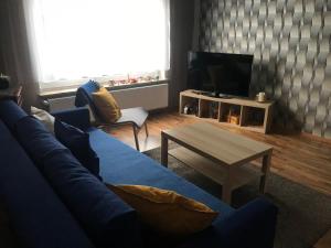 a living room with a blue couch and a table at Ferienwohnung Von Paris in Petersberg