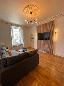 a living room with a couch and a flat screen tv at 1 Bed Apartment (sleeps 4) on Leith Walk in Edinburgh