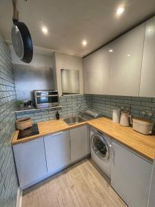 una cucina con lavandino e lavatrice di 1 Bed Apartment (sleeps 4) on Leith Walk a Edimburgo