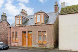 an old brick house with orange doors and windows at Glengate - Traditional home in Kirriemuir in Kirriemuir