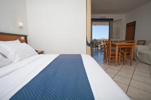 een slaapkamer met een bed, een tafel en stoelen bij Baraka Apartments in Scoglitti +18 foto's