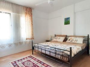 a bedroom with a bed and a window and a rug at Ertem Apart in Datca