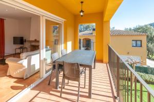 patio con mesa y sillas en el balcón en Villa la Roca en Sant Antoni de Calonge