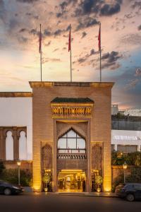 un bâtiment avec deux drapeaux au-dessus dans l'établissement La Tour Hassan Palace, à Rabat