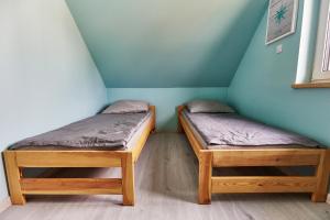 2 łóżka pojedyncze w pokoju ze ścianą w obiekcie Zatoka Perska - dom Francuz z opcją gorącej banii nad jeziorem Tarnobrzeskim w Tarnobrzegu