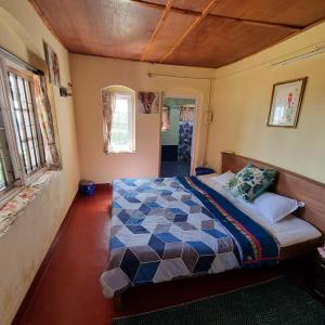 um quarto com uma cama num quarto com janelas em Zeus Bungalow em Kotagiri