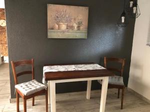 a dining room table and two chairs and a painting at K4T guest unit in Groblersdal