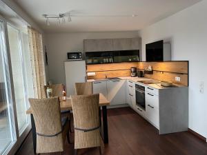 eine Küche mit einem Tisch und Stühlen im Zimmer in der Unterkunft Ferienwohnungen Residenz Hohe Lith - Duhnen in Cuxhaven