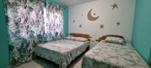 um quarto com 2 camas individuais e uma janela em Casa Hostel San Andres em San Andrés
