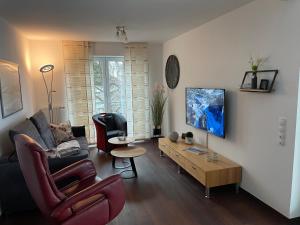 ein Wohnzimmer mit einem Sofa und einem Tisch in der Unterkunft Ferienwohnungen Residenz Hohe Lith - Duhnen in Cuxhaven