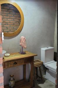 uma casa de banho com uma mesa, um WC e um espelho. em CASA AZUL São Pedro em São Pedro