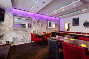 a restaurant with tables and chairs and purple walls at Best Western Motala Stadshotell in Motala