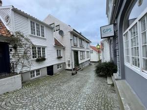 a cobblestone street in a town with white buildings at Brand-New 2bd Apt in Heart of Stavanger 0 min to Downtown in Stavanger