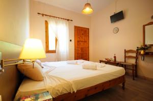 a bedroom with a bed with a lamp and a window at Mr. Greek Villa in Petra