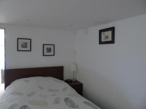 een slaapkamer met een bed en drie foto's aan de muur bij Studio Han Sur Lesse in Han-sur-Lesse