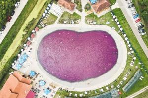 ein großer Pool mit lila Wasser in einem Park in der Unterkunft Apartments Iles in Pačir