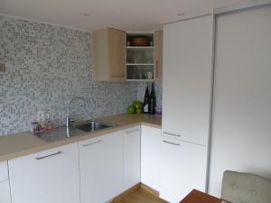 una cocina con armarios blancos y fregadero en Studio Han Sur Lesse, en Han-sur-Lesse