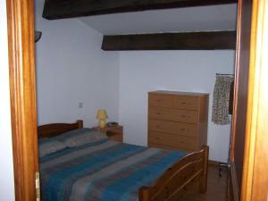 a bedroom with a bed and a wooden dresser at Le Cévenn'hols in Le Vigan