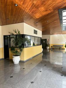 a lobby with a potted plant in a building at Edifício Gorja in Praia Grande