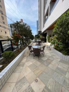 a patio with chairs and a table on a sidewalk at Edifício Gorja in Praia Grande